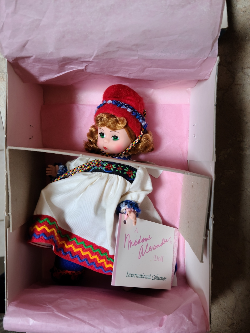 Madame Alexander Doll in White Dress with Red Hat and Multicolor Trim
